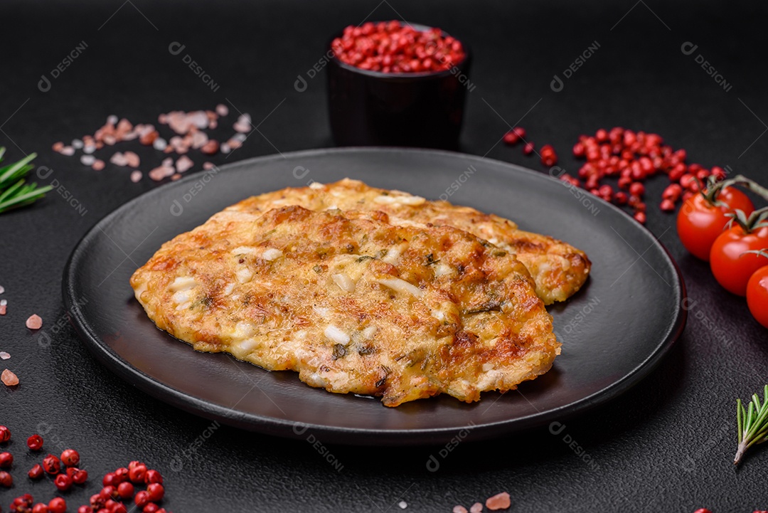 Delicioso peito de frango frito em massa com mostarda, sal, especiarias e queijo sobre fundo escuro de concreto