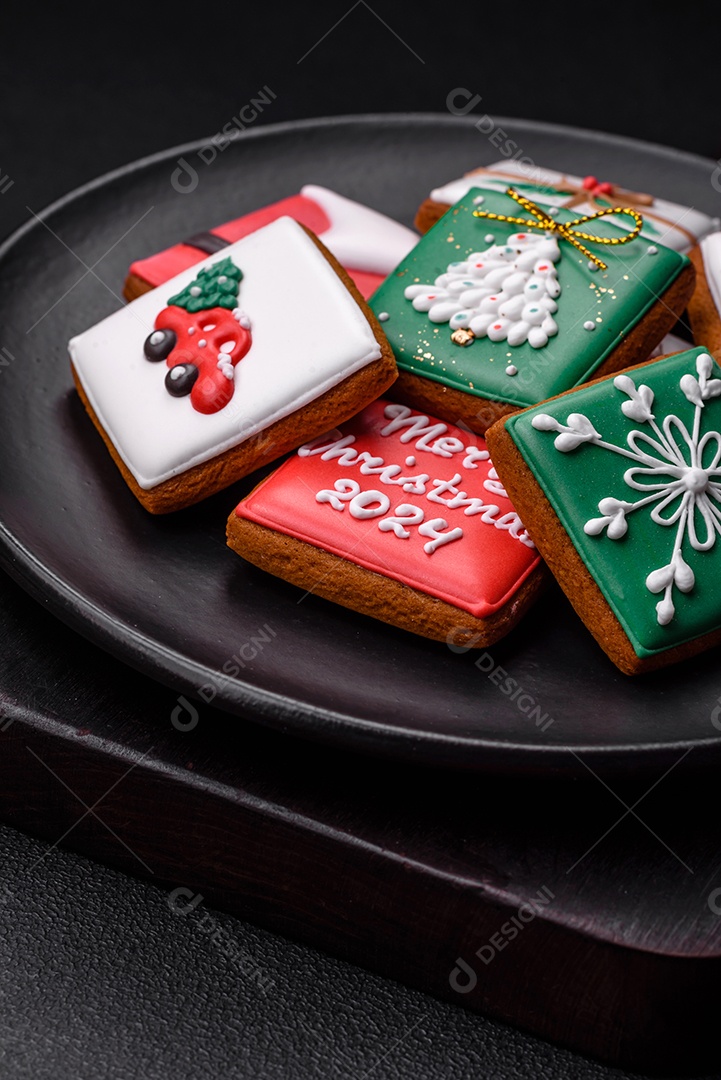 Lindos biscoitos de gengibre de Natal coloridos para o design e decoração da mesa festiva sobre um fundo de concreto texturizado