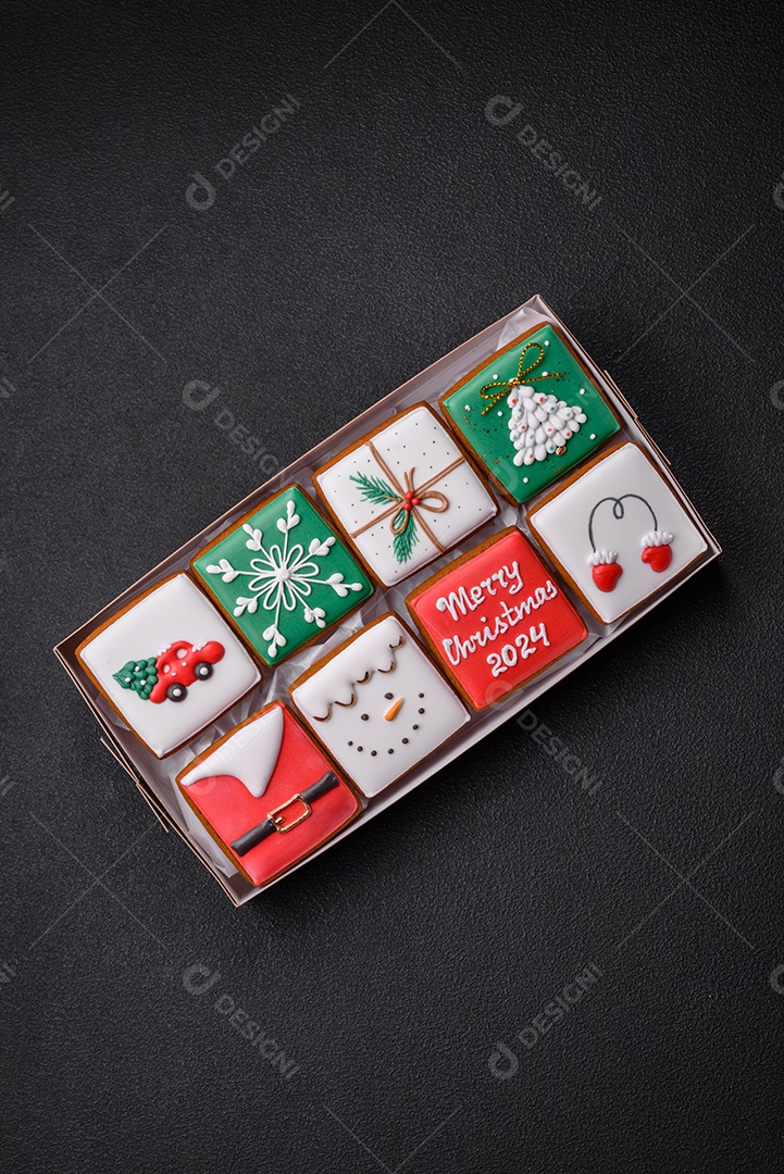 Lindos biscoitos de gengibre de Natal coloridos para o design e decoração da mesa festiva sobre um fundo de concreto texturizado