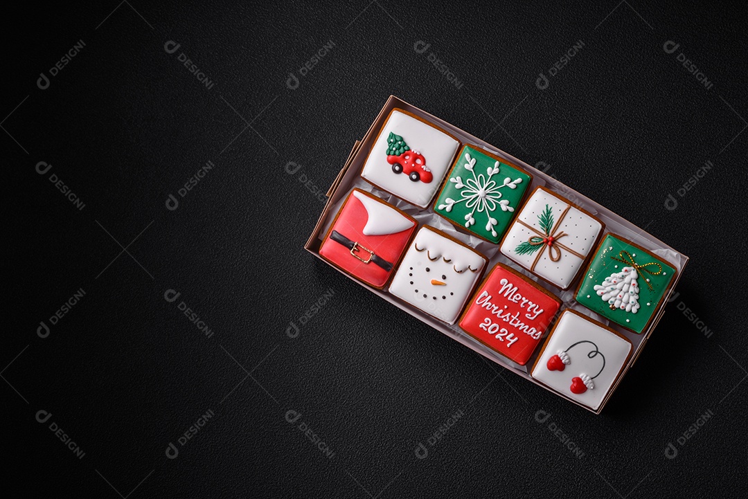 Lindos biscoitos de gengibre de Natal coloridos para o design e decoração da mesa festiva sobre um fundo de concreto texturizado