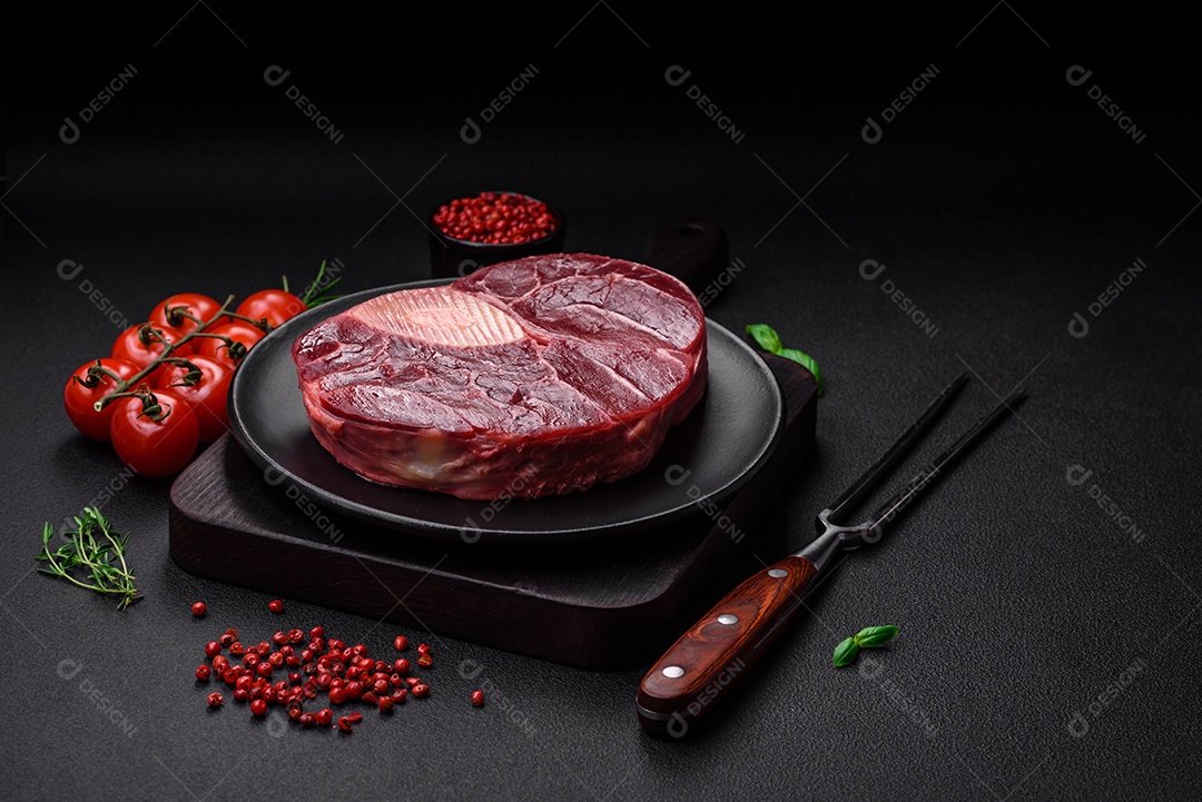 Bife de ossobuco de carne fresca com sal, especiarias e ervas em fundo de concreto texturizado