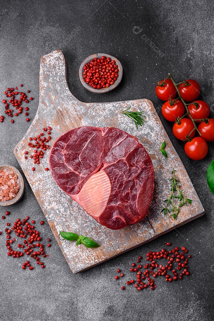 Bife de ossobuco de carne fresca com sal, especiarias e ervas em fundo de concreto texturizado