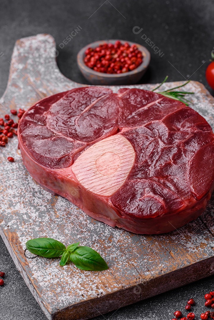 Bife de ossobuco de carne fresca com sal, especiarias e ervas em fundo de concreto texturizado