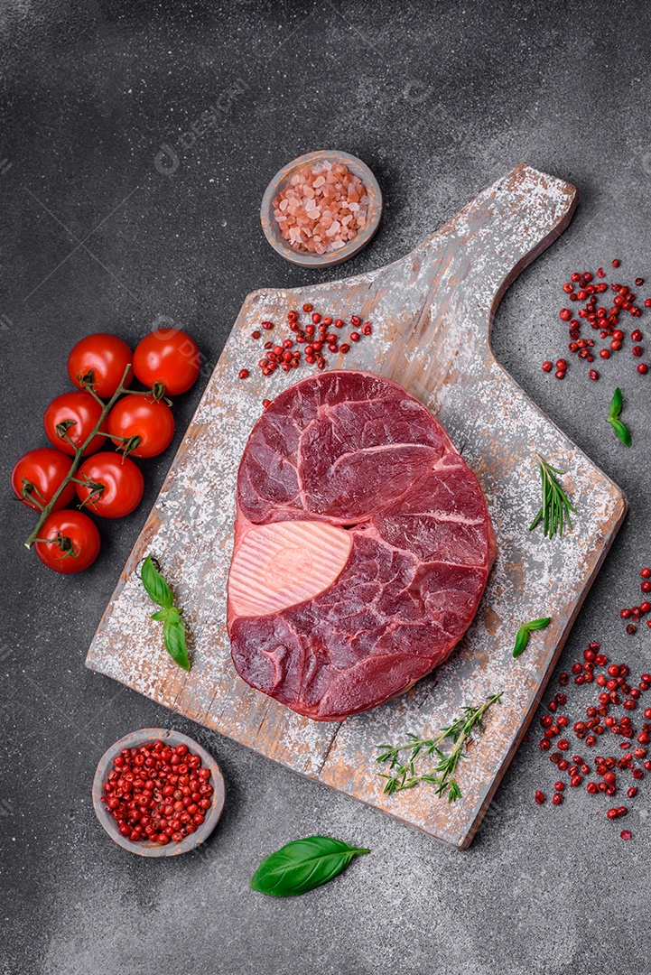 Bife de ossobuco de carne fresca com sal, especiarias e ervas em fundo de concreto texturizado