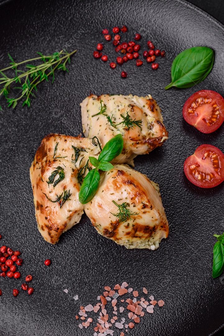 Delicioso frango suculento, espetos de peru com sal, especiarias e ervas sobre um fundo escuro de concreto