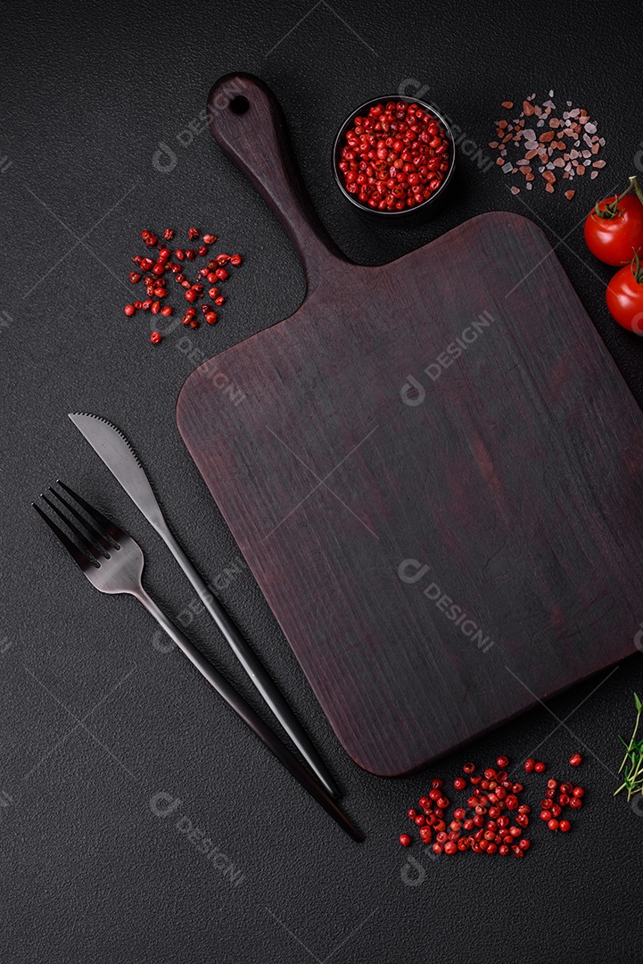 Ingredientes para cozinhar tomate cereja, sal, especiarias e ervas sobre um fundo escuro de concreto