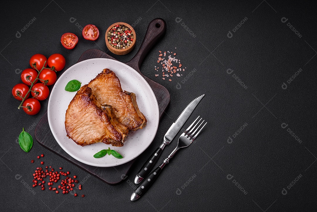 Ingredientes para cozinhar tomate cereja, sal, especiarias e ervas sobre um fundo escuro de concreto