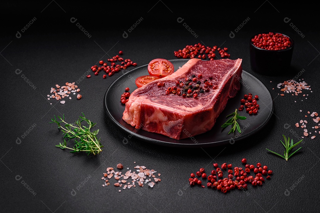 Bife fresco e suculento de Nova Iorque com sal, especiarias e ervas em fundo escuro de concreto