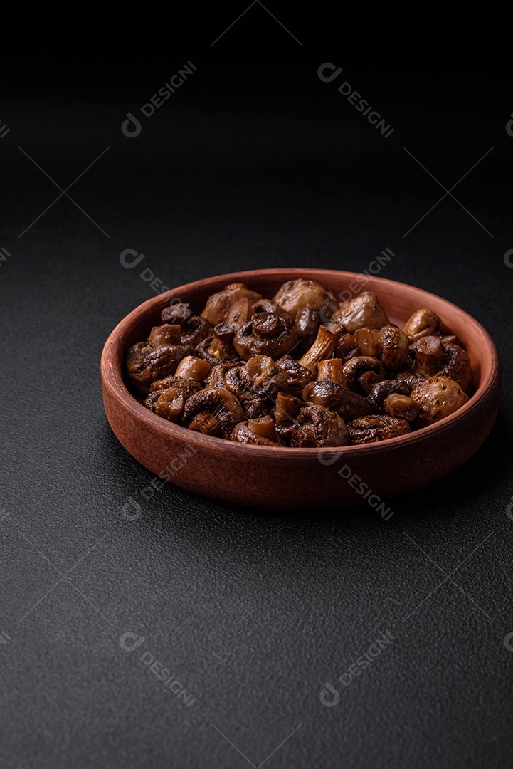 Deliciosos cogumelos champignon com sal, especiarias e ervas grelhados num prato de cerâmica