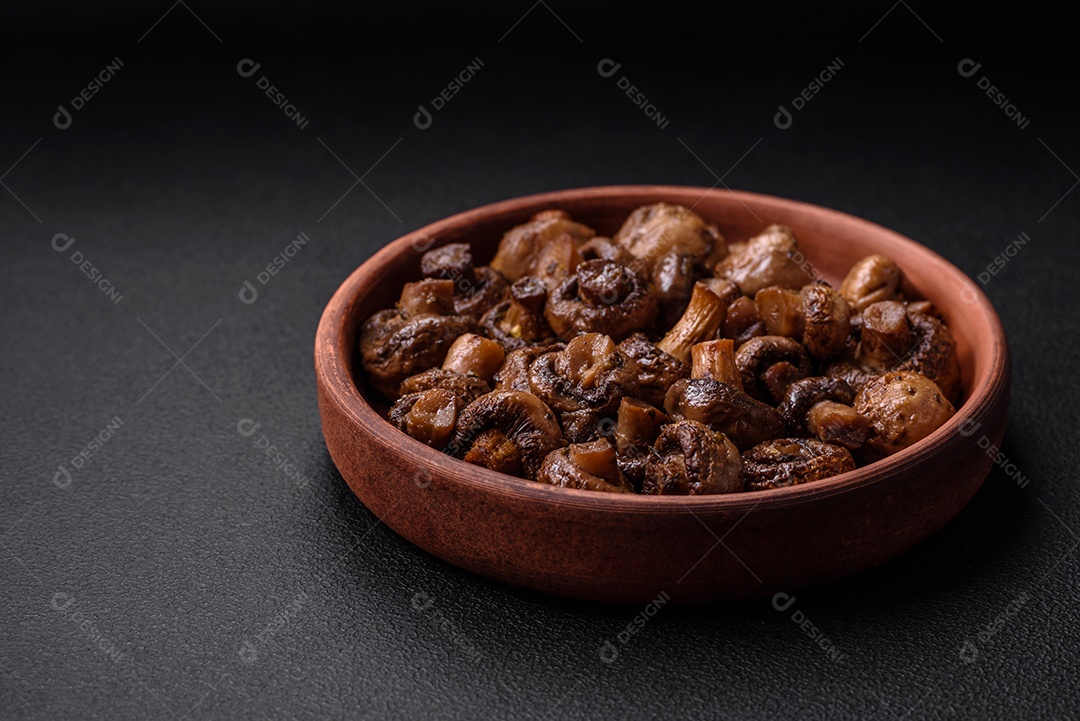 Deliciosos cogumelos champignon com sal, especiarias e ervas grelhados num prato de cerâmica