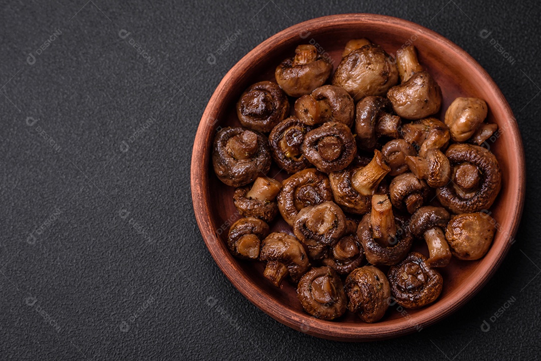 Deliciosos cogumelos champignon com sal, especiarias e ervas grelhados num prato de cerâmica