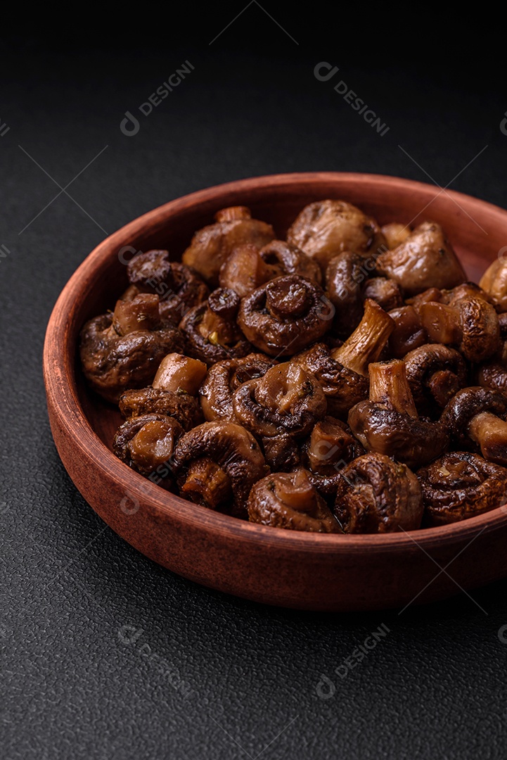 Deliciosos cogumelos champignon com sal, especiarias e ervas grelhados num prato de cerâmica