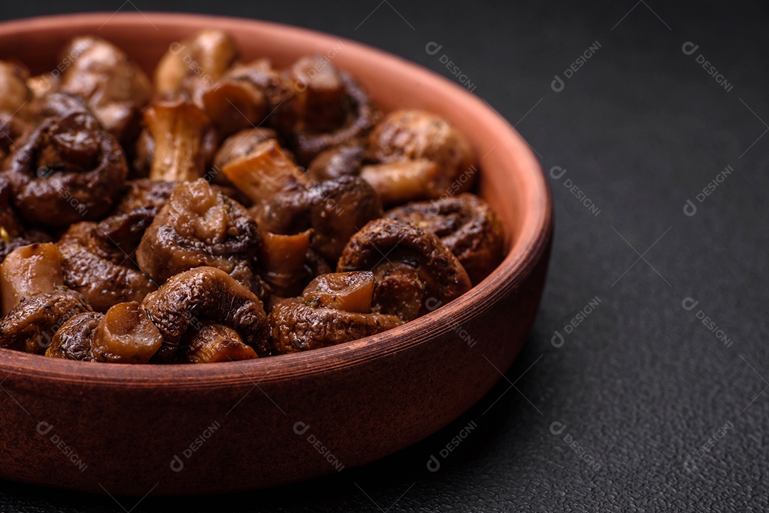 Deliciosos cogumelos champignon com sal, especiarias e ervas grelhados num prato de cerâmica