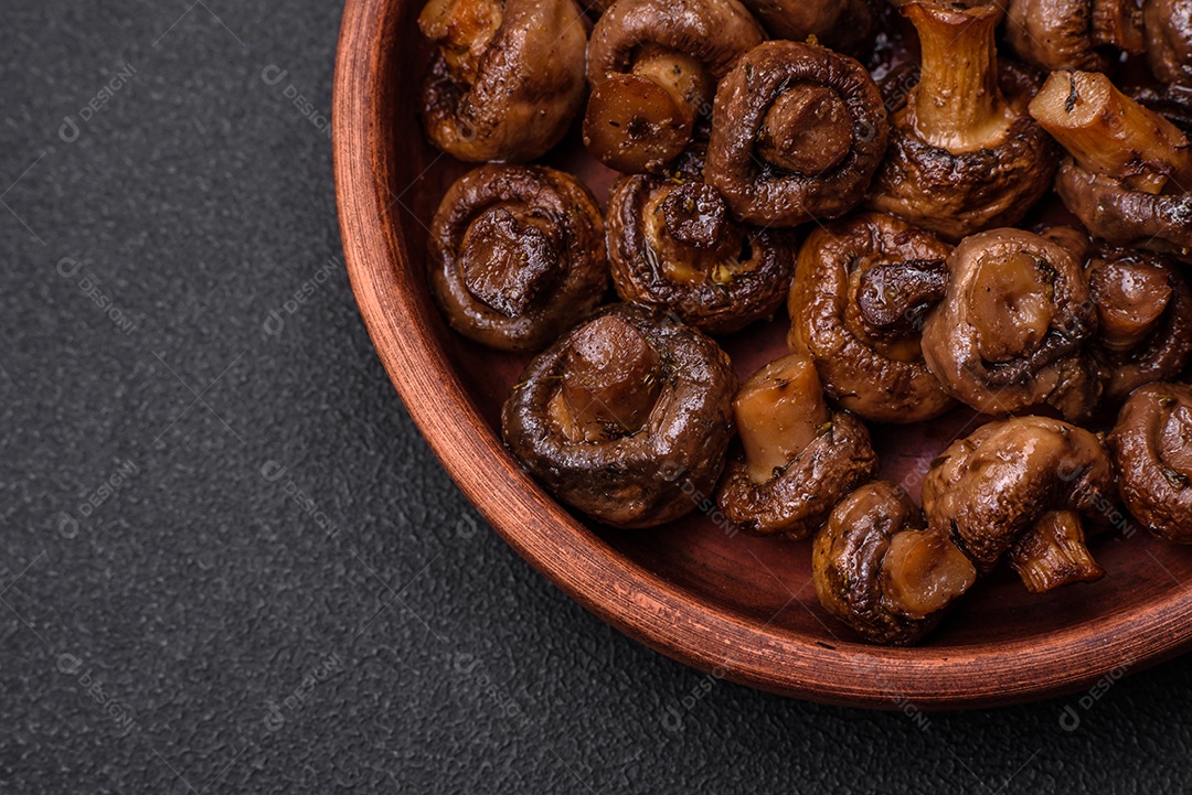 Deliciosos cogumelos champignon com sal, especiarias e ervas grelhados num prato de cerâmica