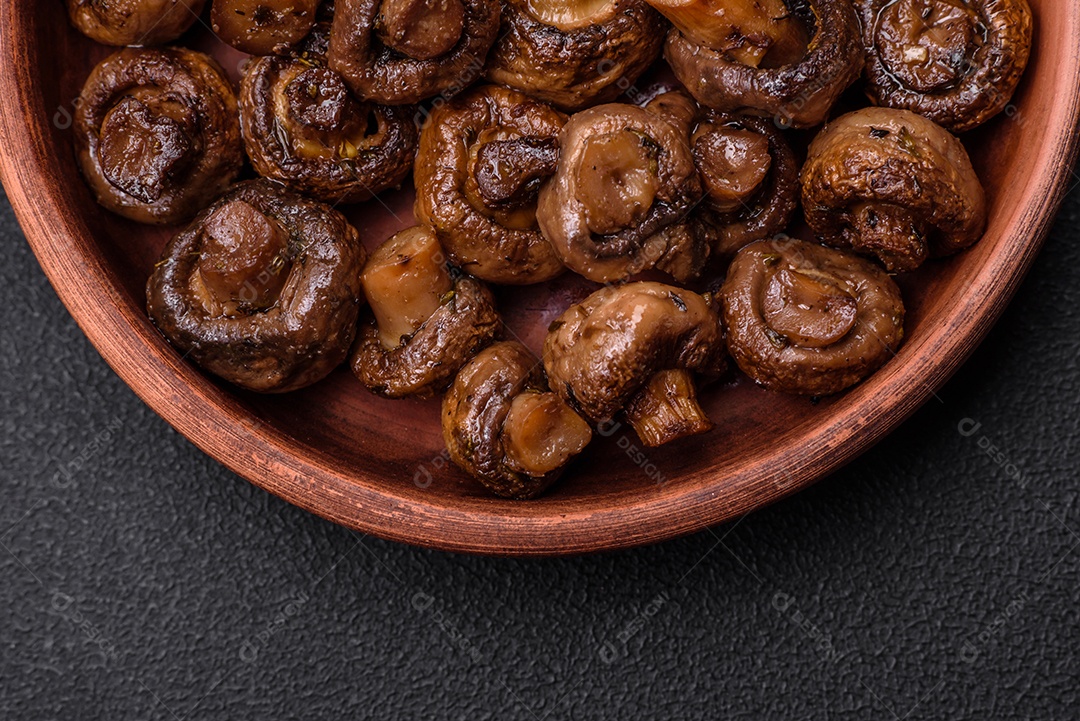 Deliciosos cogumelos champignon com sal, especiarias e ervas grelhados num prato de cerâmica