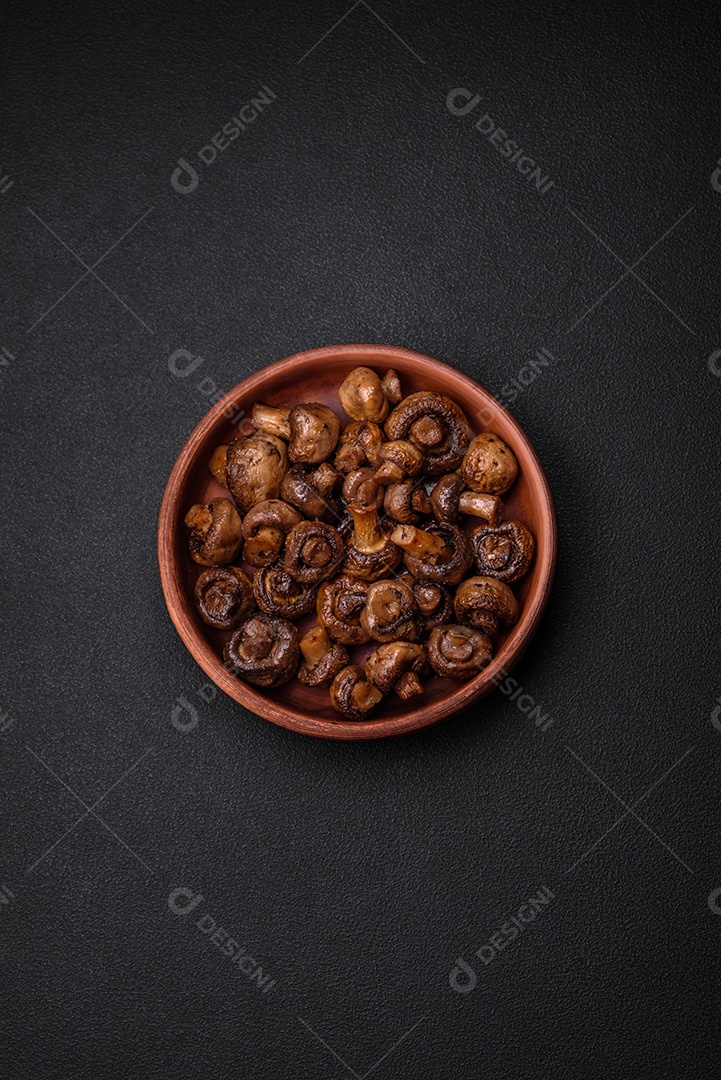 Deliciosos cogumelos champignon com sal, especiarias e ervas grelhados num prato de cerâmica