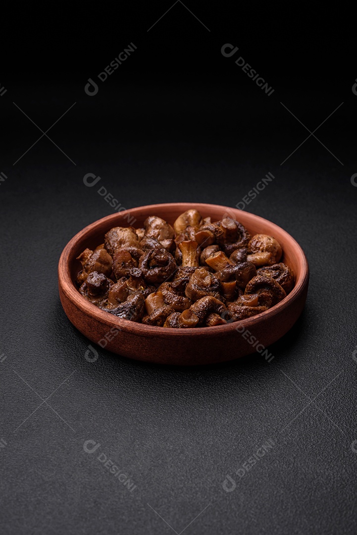 Deliciosos cogumelos champignon com sal, especiarias e ervas grelhados num prato de cerâmica