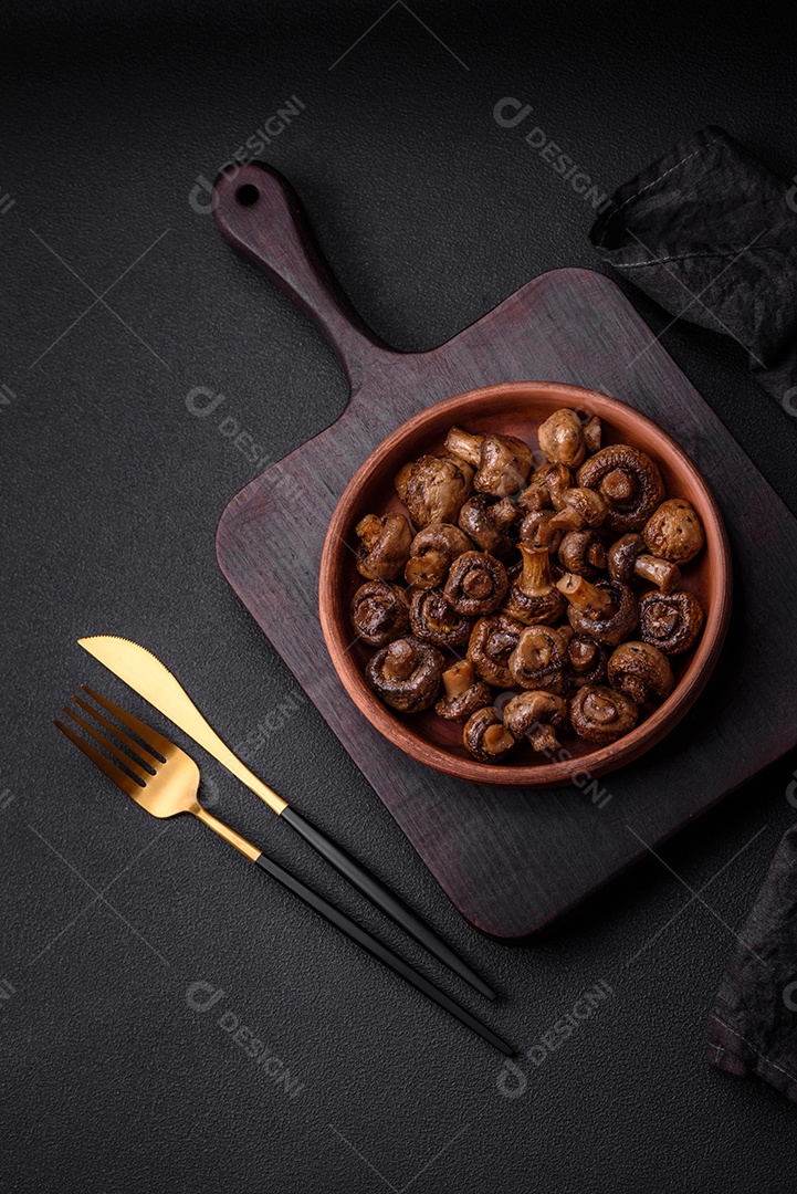 Deliciosos cogumelos champignon com sal, especiarias e ervas grelhados num prato de cerâmica