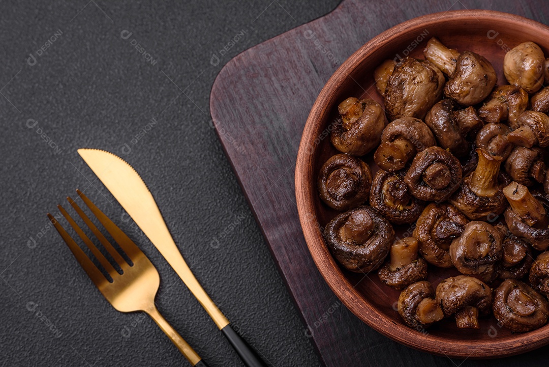 Deliciosos cogumelos champignon com sal, especiarias e ervas grelhados num prato de cerâmica