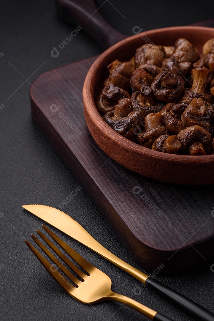 Deliciosos cogumelos champignon com sal, especiarias e ervas grelhados num prato de cerâmica