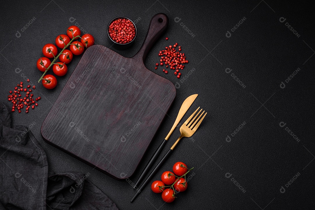 Ingredientes para cozinhar tomate cereja, sal, especiarias e ervas sobre um fundo escuro de concreto