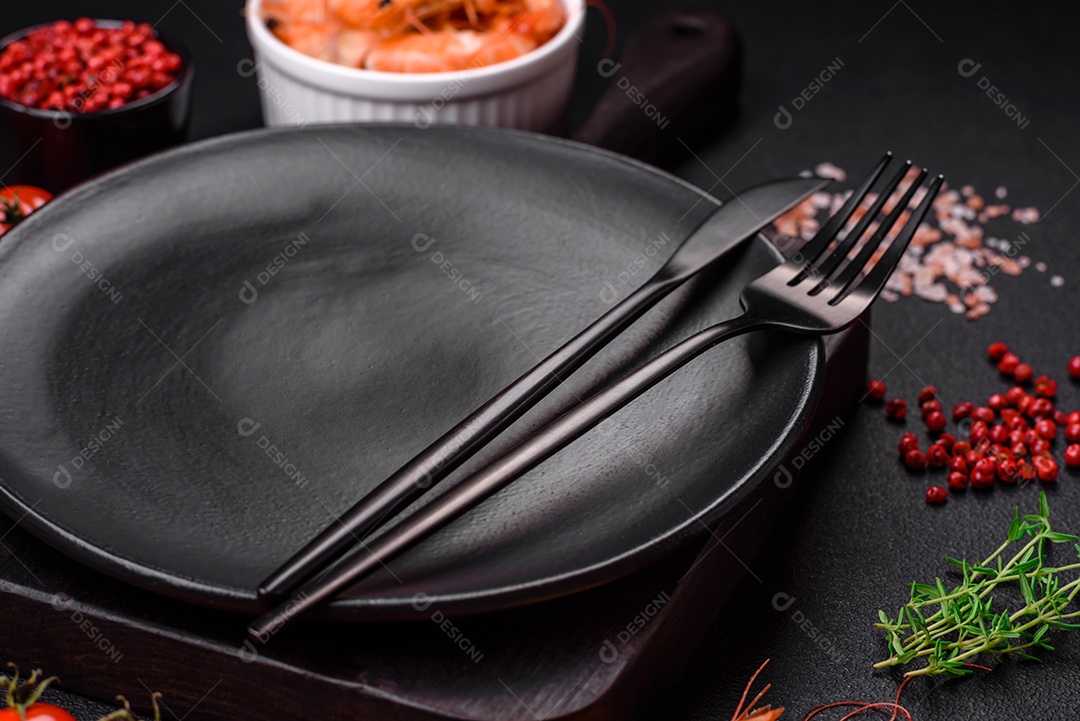 Ingredientes para cozinhar tomate cereja, camarão, sal e especiarias com lugar para inscrição em fundo escuro de concreto