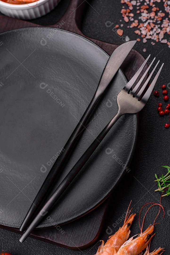 Ingredientes para cozinhar tomate cereja, camarão, sal e especiarias com lugar para inscrição em fundo escuro de concreto