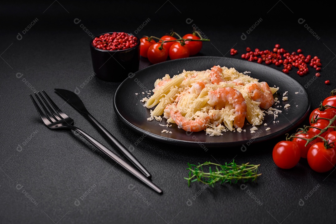 Deliciosa massa penna fresca com camarão, molho, queijo, sal e especiarias sobre um fundo escuro de concreto