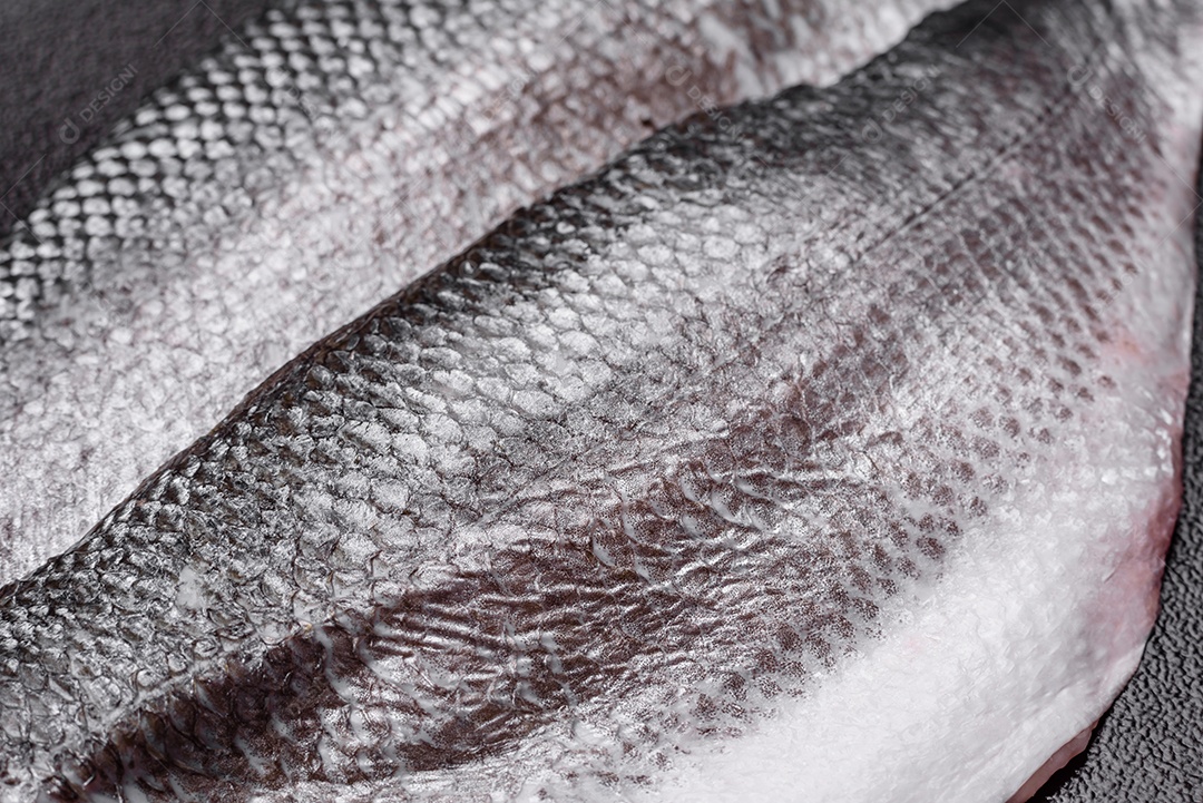 Filé de peixe robalo cru com sal, especiarias e ervas num prato cerâmico preparado para assar