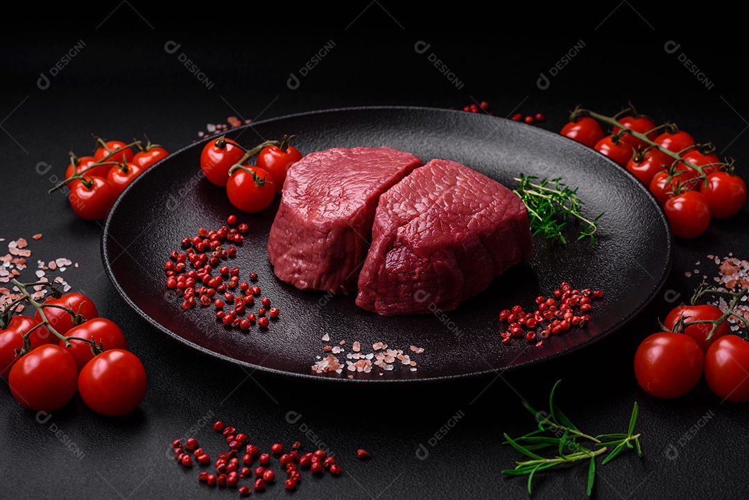 Bife cru redondo com sal, especiarias e ervas preparadas para grelhar em um fundo texturizado