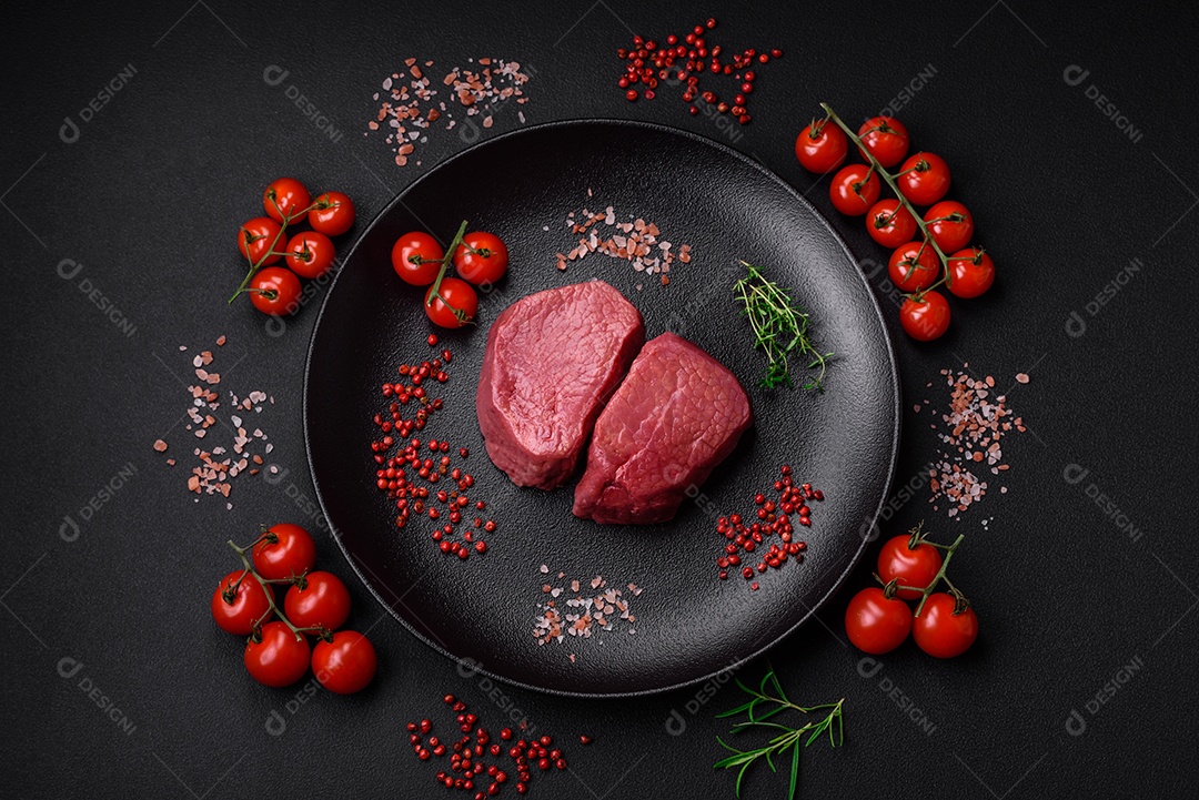 Bife cru redondo com sal, especiarias e ervas preparadas para grelhar em um fundo texturizado