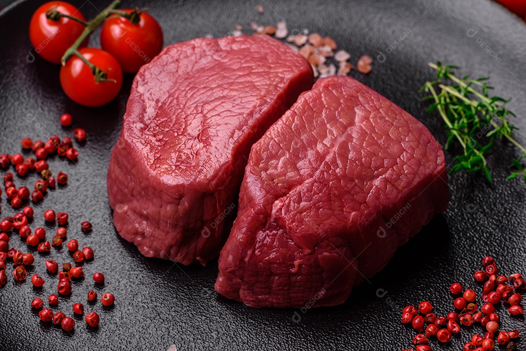 Bife cru redondo com sal, especiarias e ervas preparadas para grelhar em um fundo texturizado