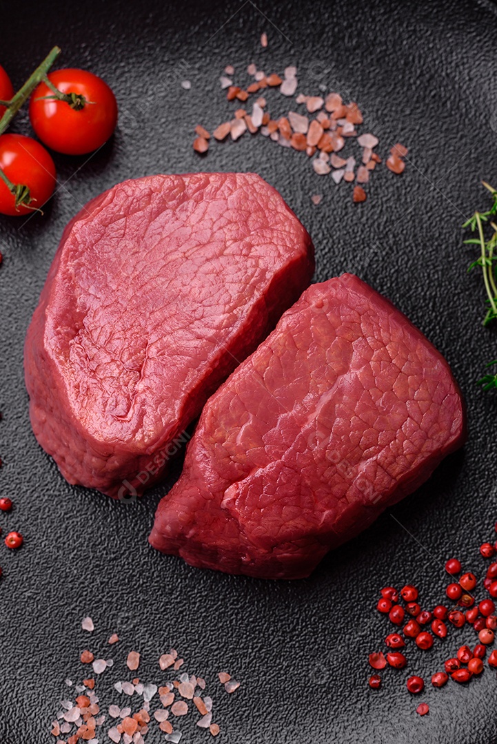 Bife cru redondo com sal, especiarias e ervas preparadas para grelhar em um fundo texturizado