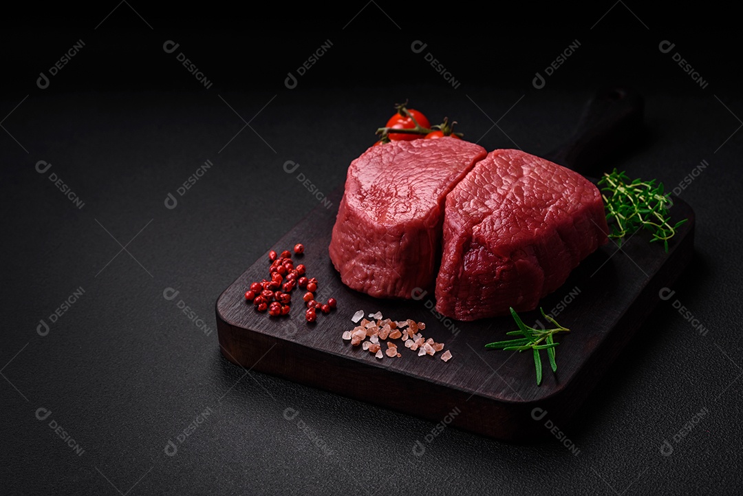 Bife cru redondo com sal, especiarias e ervas preparadas para grelhar em um fundo texturizado