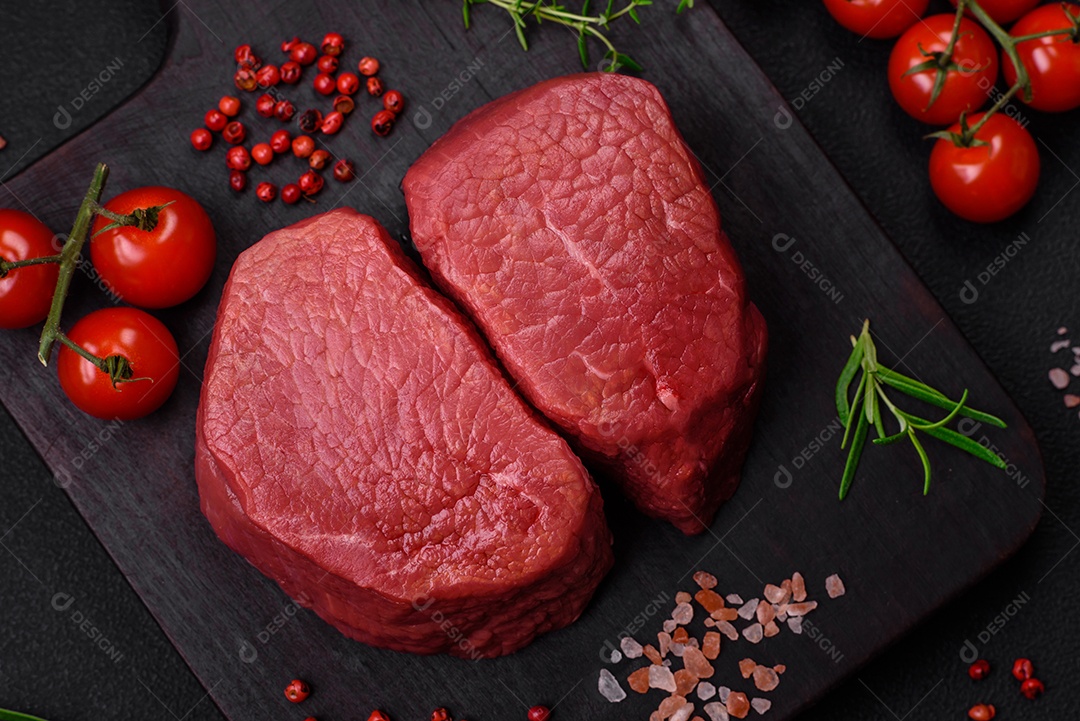 Bife cru redondo com sal, especiarias e ervas preparadas para grelhar em um fundo texturizado