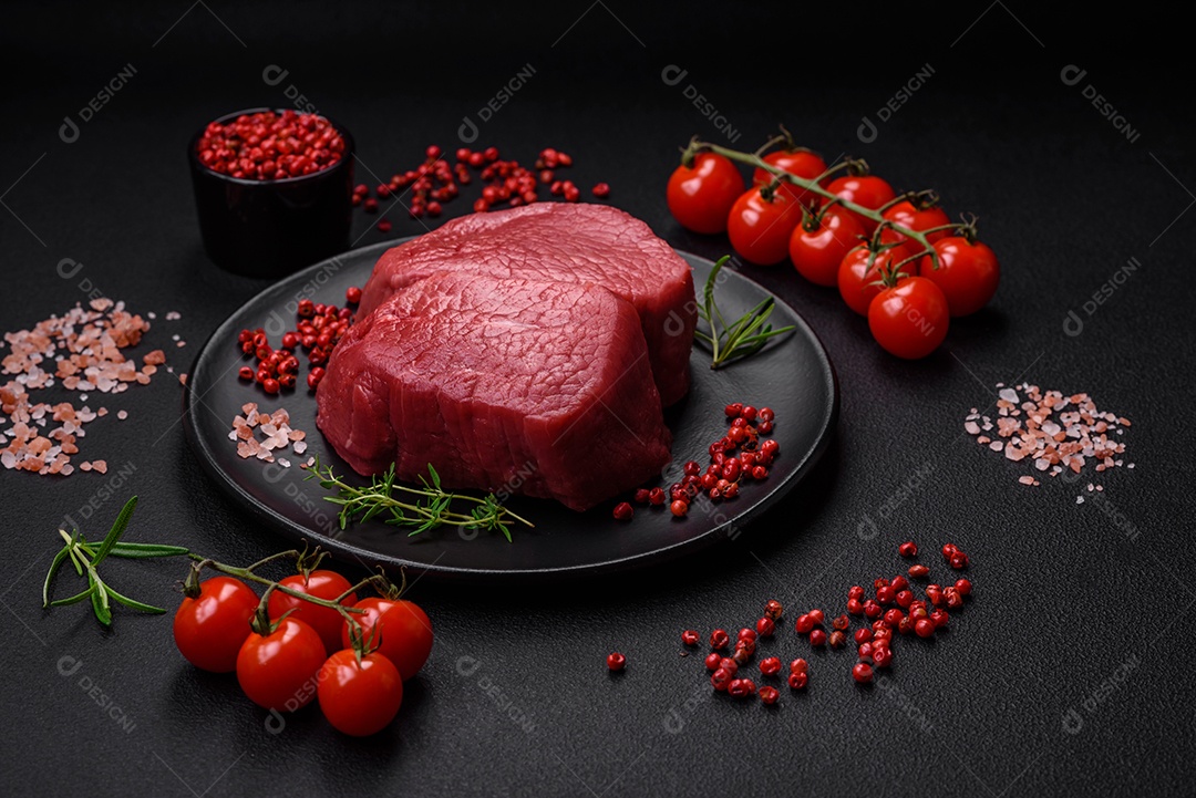 Bife cru redondo com sal, especiarias e ervas preparadas para grelhar em um fundo texturizado