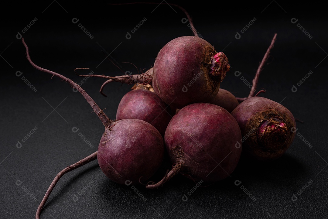 Beterraba crua fresca em forma de tubérculos sobre um fundo de concreto texturizado. Ingredientes Vegetarianos