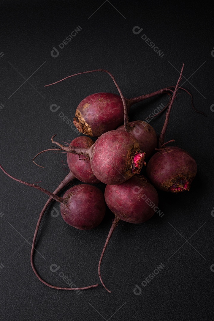 Beterraba crua fresca em forma de tubérculos sobre um fundo de concreto texturizado. Ingredientes Vegetarianos