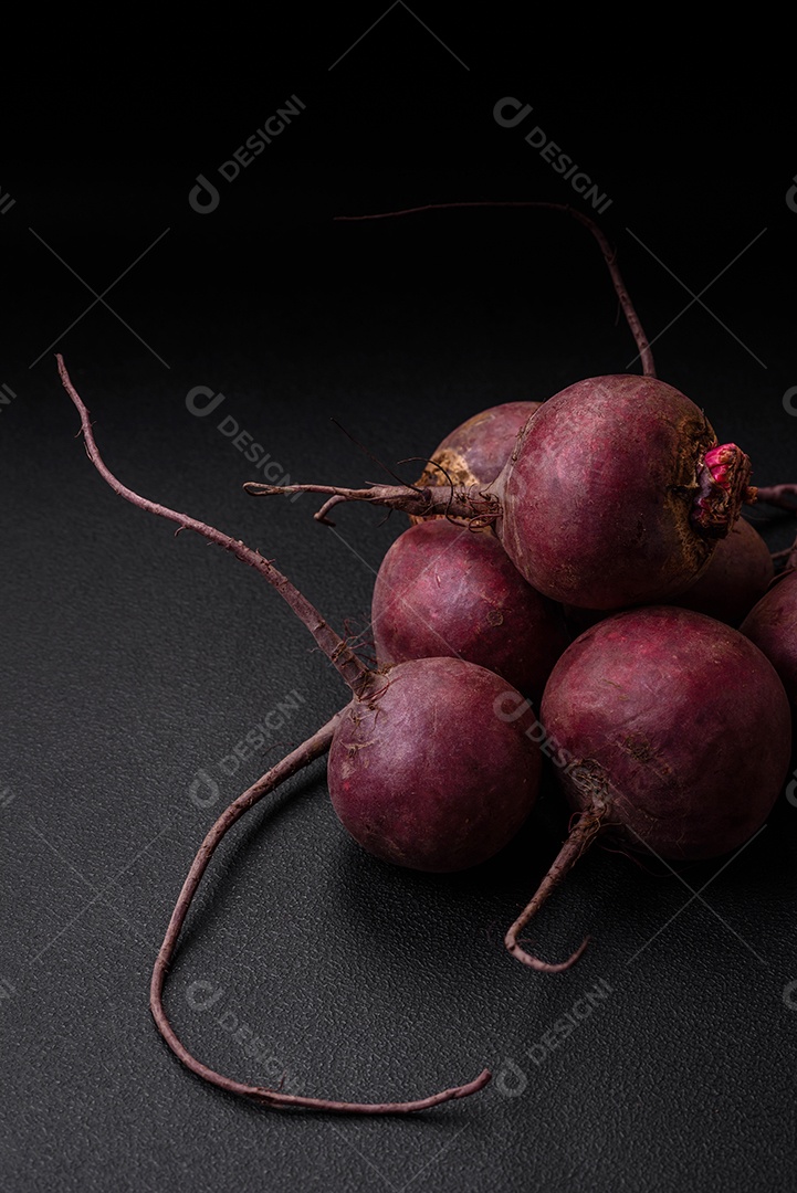 Beterraba crua fresca em forma de tubérculos sobre um fundo de concreto texturizado. Ingredientes Vegetarianos