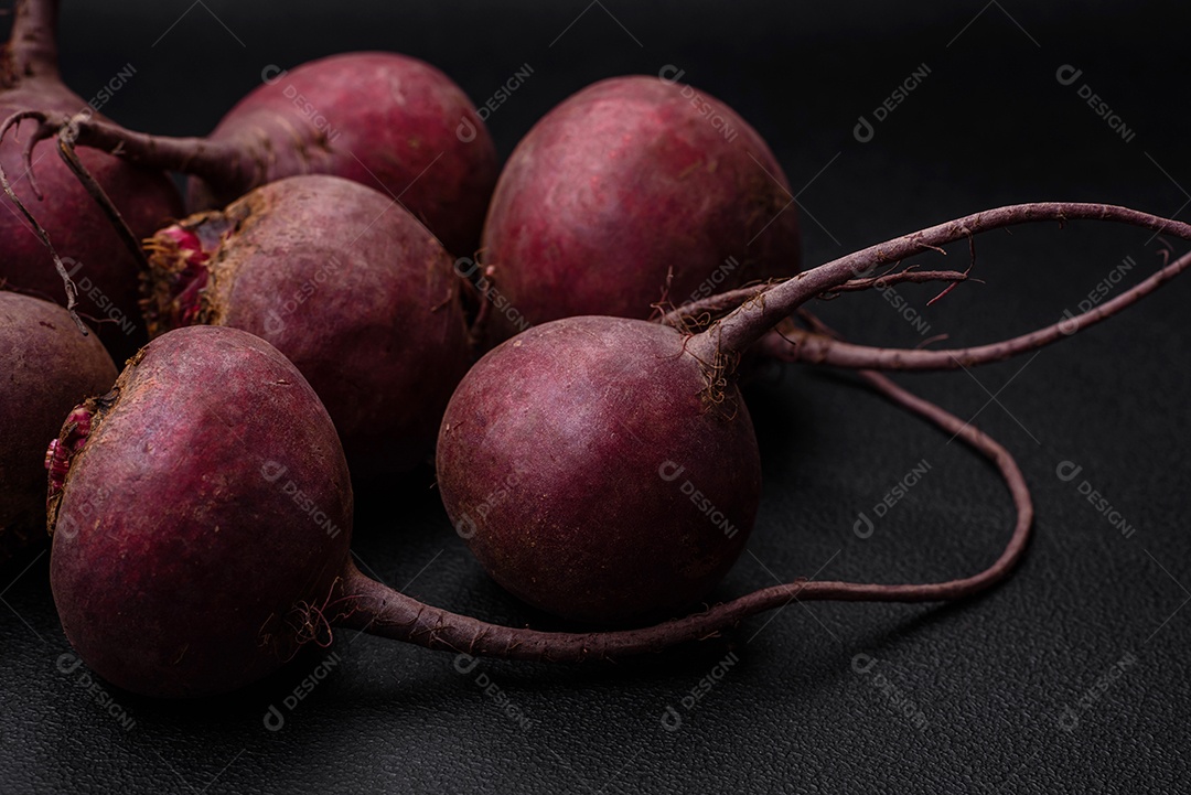 Beterraba crua fresca em forma de tubérculos sobre um fundo de concreto texturizado. Ingredientes Vegetarianos