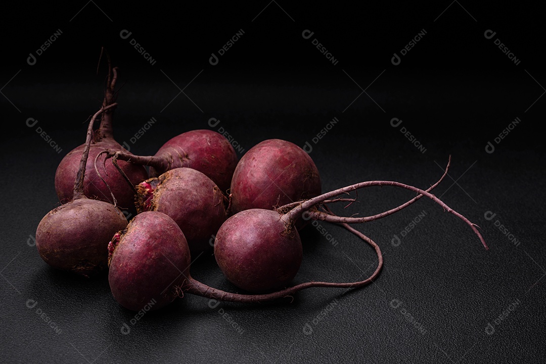 Beterraba crua fresca em forma de tubérculos sobre um fundo de concreto texturizado. Ingredientes Vegetarianos