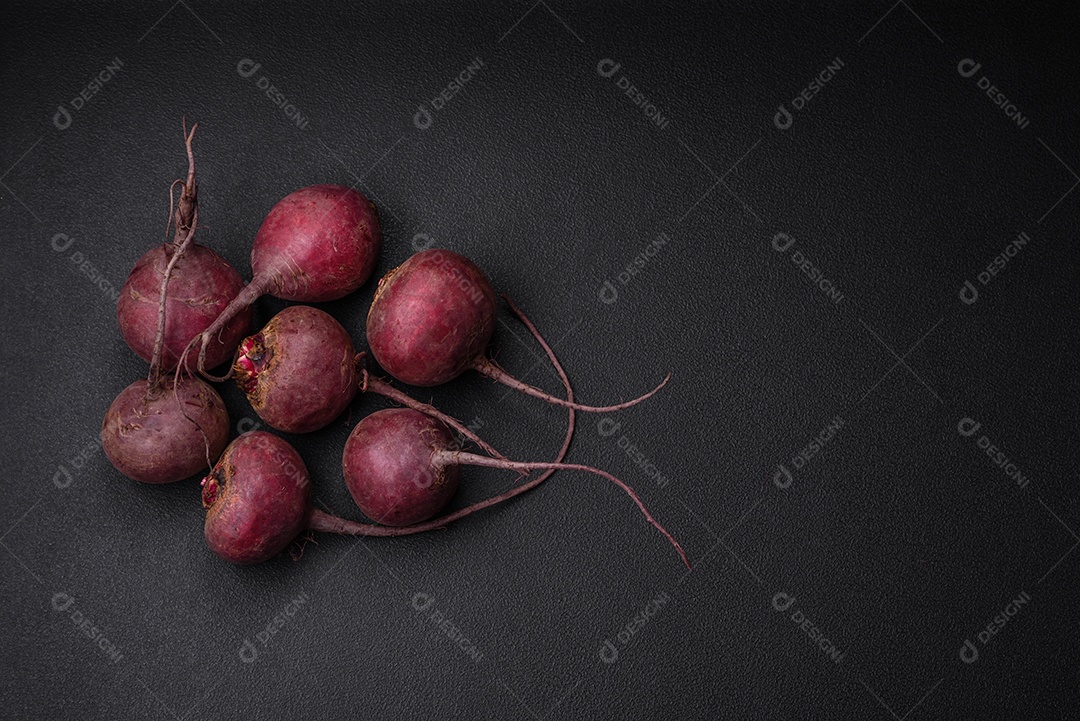 Beterraba crua fresca em forma de tubérculos sobre um fundo de concreto texturizado. Ingredientes Vegetarianos