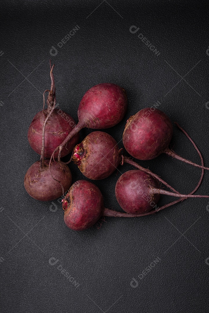 Beterraba crua fresca em forma de tubérculos sobre um fundo de concreto texturizado. Ingredientes Vegetarianos
