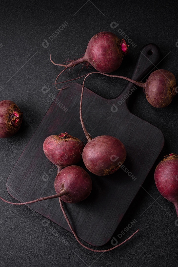 Beterraba crua fresca em forma de tubérculos sobre um fundo de concreto texturizado. Ingredientes Vegetarianos