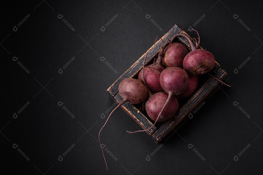 Beterraba crua fresca em forma de tubérculos sobre um fundo de concreto texturizado. Ingredientes Vegetarianos