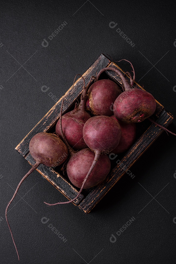 Beterraba crua fresca em forma de tubérculos sobre um fundo de concreto texturizado. Ingredientes Vegetarianos