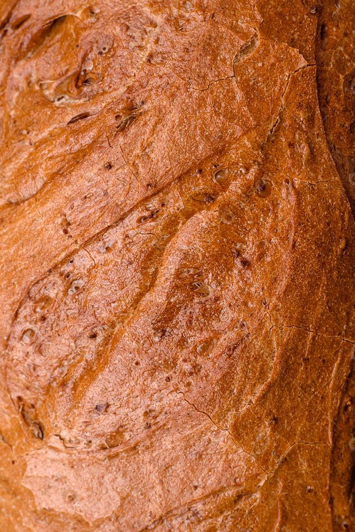 Delicioso pão branco fresco e crocante com grãos e sementes sobre um fundo escuro textural