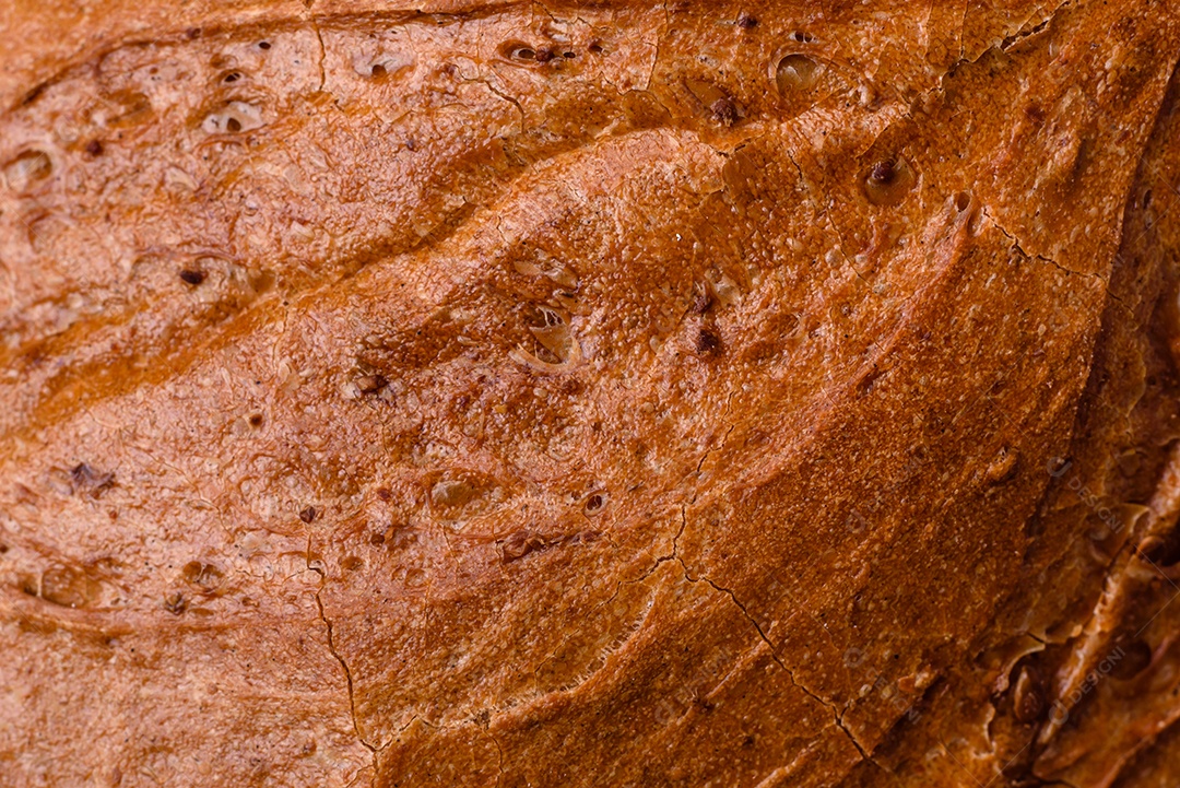 Delicioso pão branco fresco e crocante com grãos e sementes sobre um fundo escuro textural