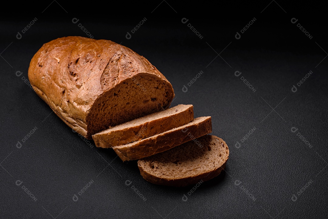 Delicioso pão branco fresco e crocante com grãos e sementes sobre um fundo escuro textural