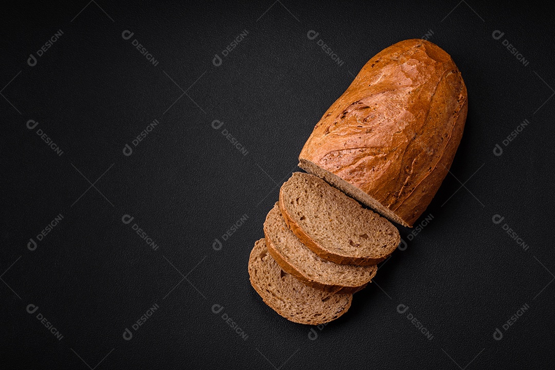 Delicioso pão branco fresco e crocante com grãos e sementes sobre um fundo escuro textural
